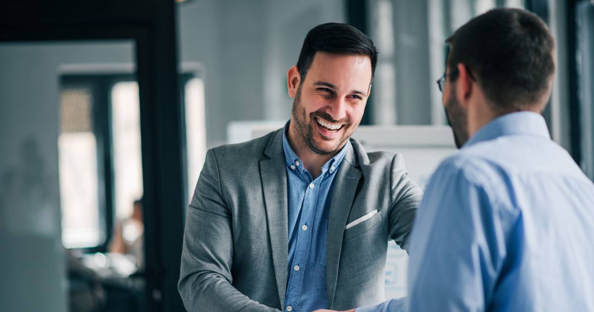 Jonge manager geeft handdruk aan nieuwe medewerker