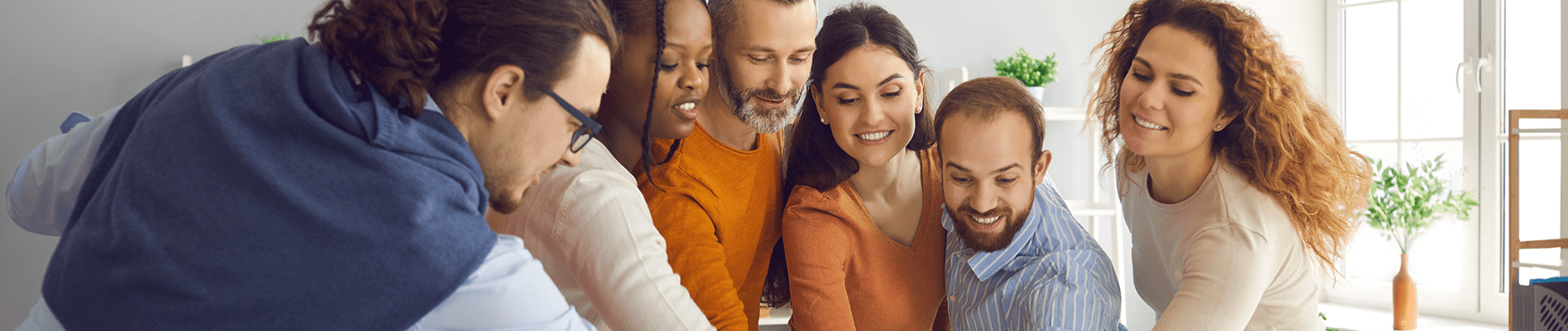Team vrolijke, gemotiveerde medewerkers met de handen bij elkaar
